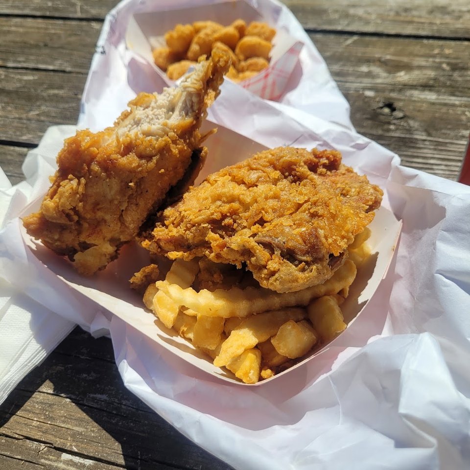 Crispy chicken pieces beside coleslaw and fries.